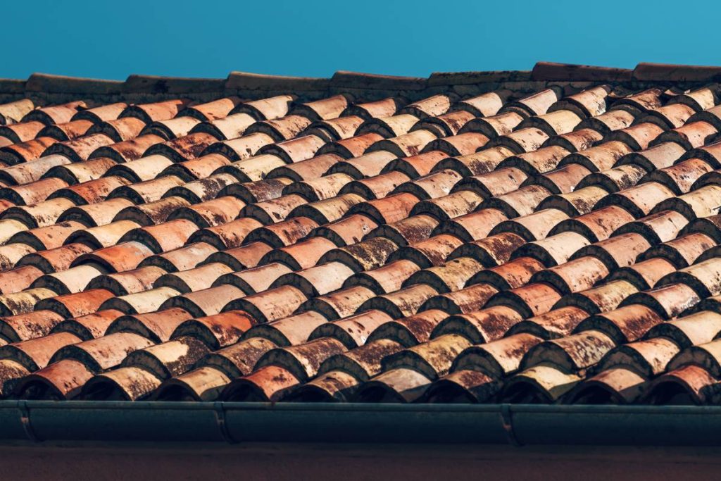 Old vintage red ceramic barrel roof tile typical for Mediterranean countries, also known as ceramida, selective focus