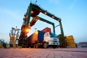 What Is Freight Forwarding? Everything You Need to Know Blurred motion of truck with cargo containers and cranes in a shipping port