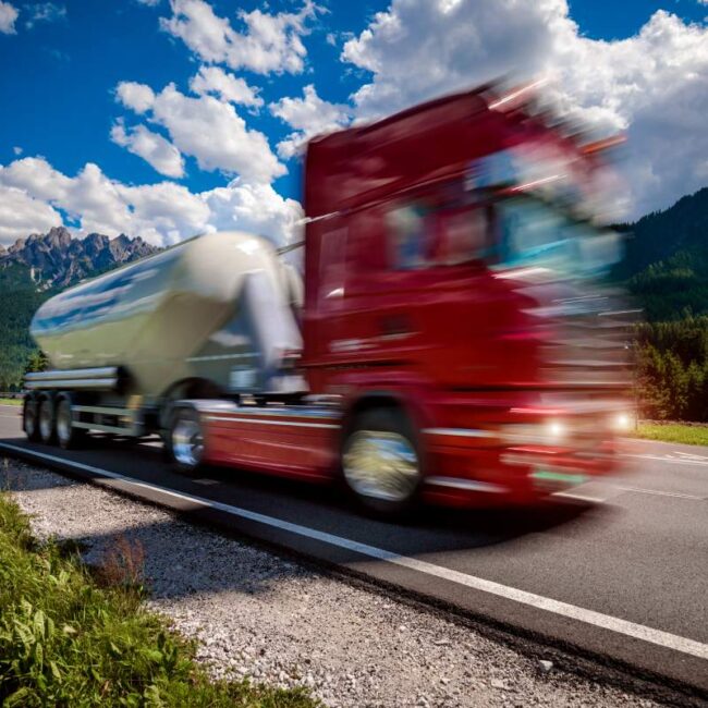 Fuel truck rushes down the highway in the background the Alps. Truck Car in motion blur.