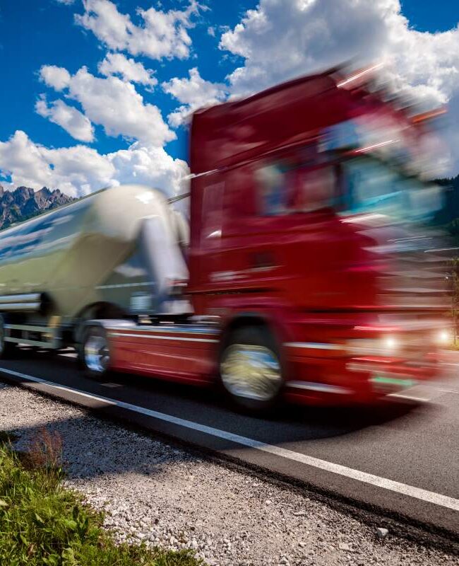 Fuel truck rushes down the highway in the background the Alps. Truck Car in motion blur.